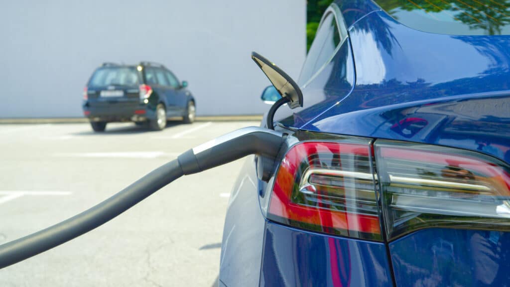 Detailed shot of a shiny new Tesla car recharging at a